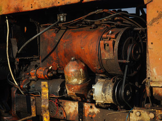 Old tractor engine. Rusty agricultural machine. Orange engine