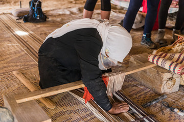 A Bedouin woman shows how to make the right fabric on a simple loom in a Bedouin village near the Mitzpe Ramon city