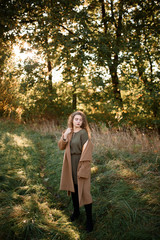 Wall Mural - Beautiful elegant woman standing in a park in autumn