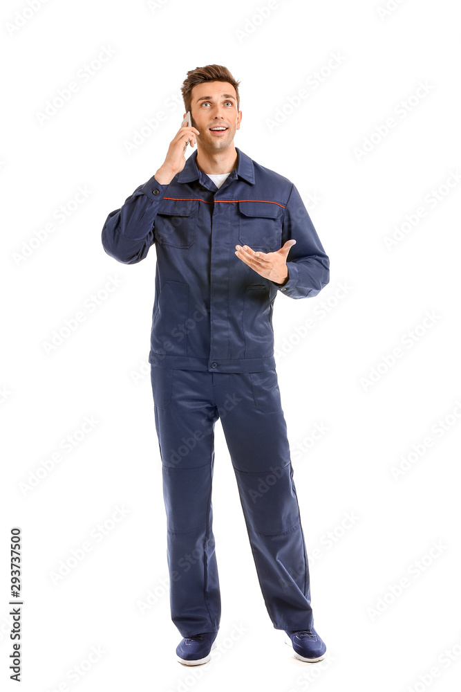Male car mechanic talking by phone on white background