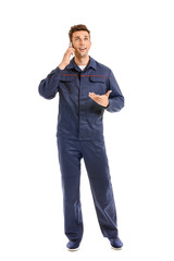 Wall Mural - Male car mechanic talking by phone on white background