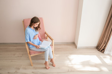 Poster - Beautiful pregnant woman reading book at home