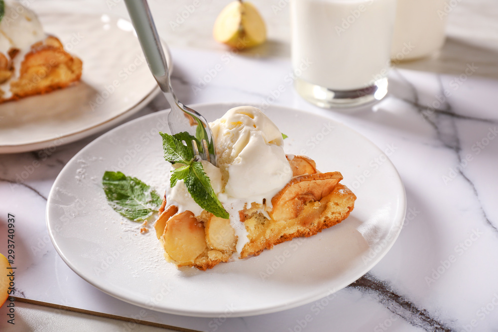 Plate with piece of apple pie and ice cream on table