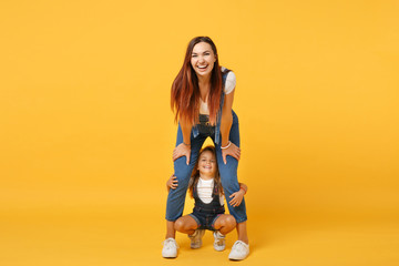 Wall Mural - Woman in light clothes have fun with cute child baby girl 4-5 years old. Mommy little kid daughter isolated on yellow background studio portrait. Mother's Day love family parenthood childhood concept.