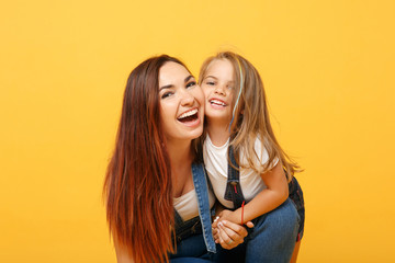 Wall Mural - Woman in light clothes have fun with cute child baby girl 4-5 years old. Mommy little kid daughter isolated on yellow background studio portrait. Mother's Day love family parenthood childhood concept.