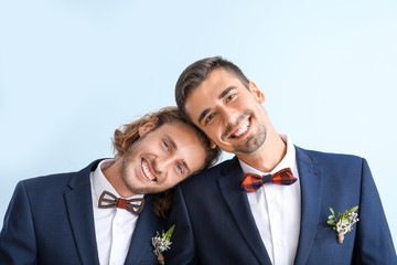 Wall Mural - Portrait of happy gay couple on their wedding day against color background