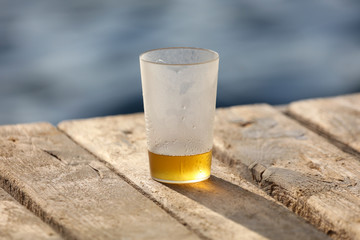 Wall Mural - Glass with beer near the water on the beach