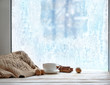 © Ju_see - cozy winter season. cup of tea or coffee, sweater, cinnamon, nuts, frozen window. home comfort in snowy cold weather. Christmas and New Year holiday background