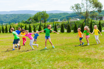 Wall Mural - Kids have fun and run outdoors, following and laughing