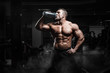© Fotokvadrat - Muscular athletic bodybuilder fitness model posing and drinks water after exercises in gym