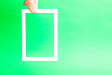 Poster - wooden light frame in a hand on a green background