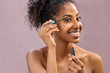 African young woman applying mascara