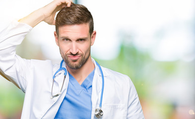 Sticker - Handsome doctor man wearing medical uniform over isolated background confuse and wonder about question. Uncertain with doubt, thinking with hand on head. Pensive concept.