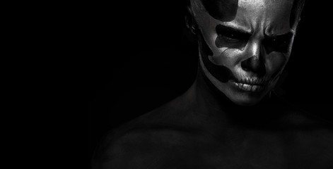 Halloween. Woman in day of the dead mask skull face art. Halloween face art on black background. Halloween make up.