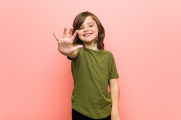 little boy smiling cheerful showing number five with fingers.