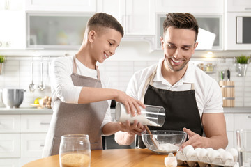 Canvas Print - Dad and son cooking together in kitchen