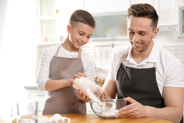 Canvas Print - Dad and son cooking together in kitchen