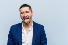 Young Business Caucasian Man Funny And Friendly Sticking Out Him Tongue.