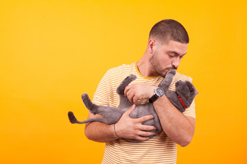 Attractive young man holding in his arms adorable cat