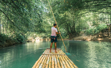  Man rowing bamboo raft, Martha Brae. Tourist boy whilst on cruise on vacation in Montego Bay, Jamaica, Caribbean.