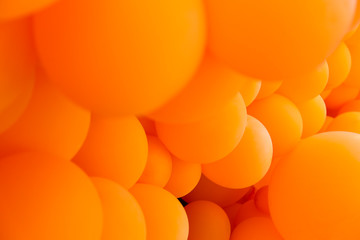 Festive composition with bunch of matte orange balloons. Macro shot, close up, background with a lot of copy space for text.