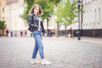 portrait of little beautiful stylish kid girl in city urban street