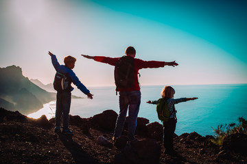 father with kids-boy and girl- enjoy travel in sunset mountains