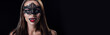 panoramic shot of naked scary vampire girl in masquerade mask showing fangs isolated on black