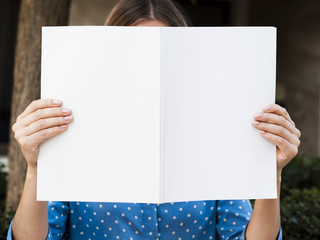 Front view woman holding a mock-up magazine