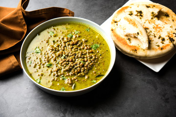 Poster - Black Masoor Dal fry or Dhaba Style Sabut Red Lentil dhal tadka in green curry, served in a bowl. selective focus