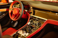 Red Luxury Car Interior. Steering Wheel, Shift Lever And Dashboard. Shallow Doff