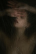 © Alberto Bogo/Stocksy - Sensual woman in dark behind plastic