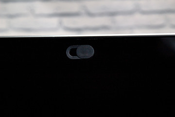 Camera Privacy Cover. Slide Webcam. Cover for a electronic device with a white brick wall.