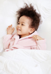 Wall Mural - Cute little girl lying in cosy bed