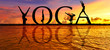 © bennymarty - YOGA word on sunset sea with of young active women stretching in Yoga pose to keep fit and health. Healthy lifestyle, flexibility training, sport activity in summer holiday.