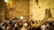 Shofar and in the background religious people pray at the Western Wall in the Holy City of Jerusalem in Israel