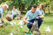 © Viktoriia - Volunteering. Young people volunteers outdoors africa boy close-up picking litter into plastic bag pensive