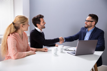 Male Business Colleague Shaking Hands In Office