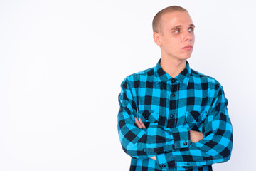 Portrait of young bald hipster man thinking with arms crossed