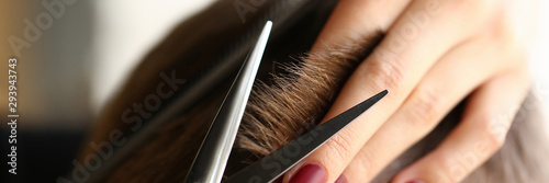 Cuadros en Lienzo Female hand hold hair scissors aganist hairdresser salon background