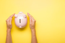 Woman Hand Putting Money Coin Into Piggy For Saving Money Wealth And Financial Concept.