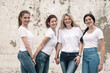 © Alena Ozerova - Group of diverse girls in tshirts and jeans over street wall