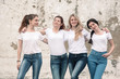 © Alena Ozerova - Group of diverse girls in tshirts and jeans over street wall