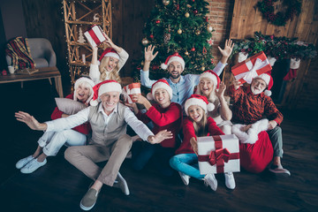 Canvas Print - Portrait of nice lovely cheerful big full family brother sister couples wearing cap hat headwear sitting on floor holding in hands gifts waving hi hello tradition loft industrial style interior house