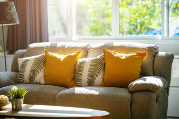 Vintage sofa and pillows in living room with sunlight in the morning. Relax corner concept.