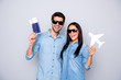 Photo of funny guy and lady holding plane tickets advice buy hot tour for low prices wear casual outfits isolated grey color background