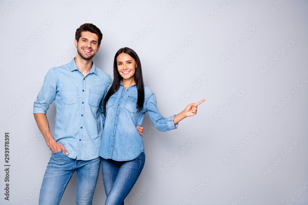 Photo of cheerful trendy charming brown haired nice cute couple of two people pointing at emptiness away wearing jeans denim jackets isolated over grey color white background - obrazy, fototapety, plakaty 