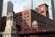 Chicago red bricks buiklding with a clock tower over red bridge