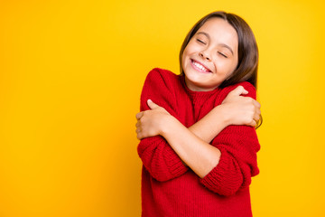 Canvas Print - Portrait of peaceful calm kid hug embrace herself enjoy warm soft comfy sweater pullover wear red stylish lifestyle clothes isolated over yellow color background