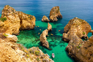 Wall Mural - Panoramic view, Ponta da Piedade near Lagos in Algarve, Portugal. Cliff rocks and tourist boat on sea at Ponta da Piedade, Algarve region, Portugal. Ponta da Piedade, Algarve region, Portugal.